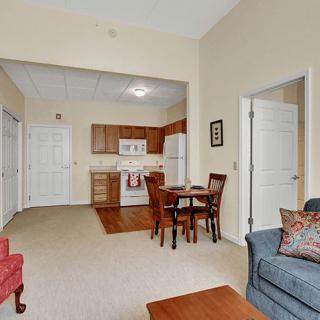 A cozy apartment living room with an open kitchen and dining area.
