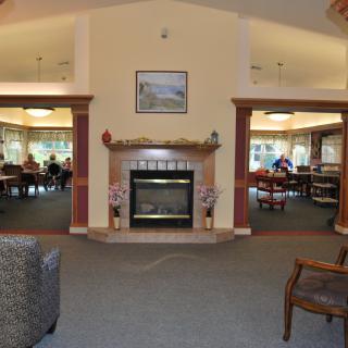 A cozy communal living room with a central fireplace and comfortable seating.