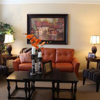 A cozy living room with a warm-toned sofa, elegant coffee table, and complementary artwork.
