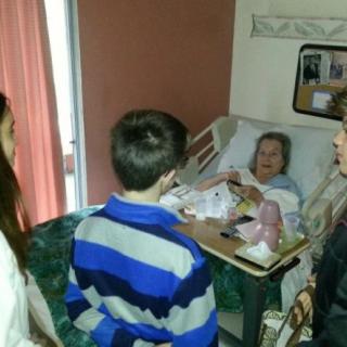 A family visiting a patient in a hospital room.