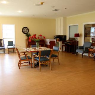A spacious and well-lit interior featuring a dining area with tables and chairs, suitable for gatherings.
