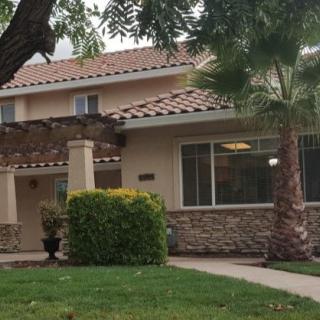 A suburban house with a stone facade and a well-maintained garden.