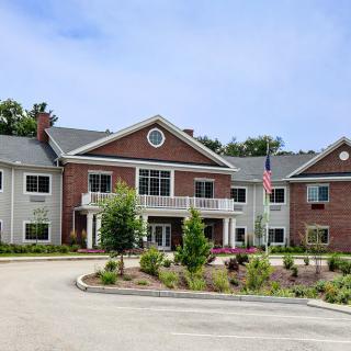 A two-story residential building with a landscaped entrance and driveway.