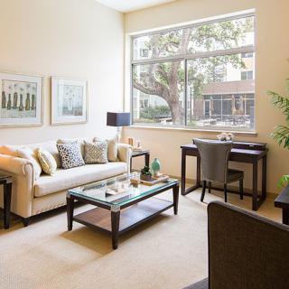 A modern living room featuring a comfortable sofa, stylish coffee table, and a desk by the window.