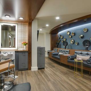 A modern salon interior featuring comfortable seating and decorative elements on the walls.