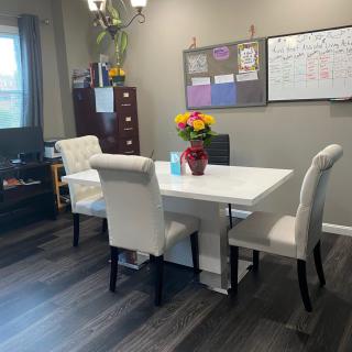 A well-organized office space with a table, chairs, and decorative elements.