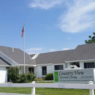 A residential healthcare facility with a sign and an American flag.