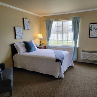 A cozy bedroom with a neatly made bed, soft lighting, and charming decor.