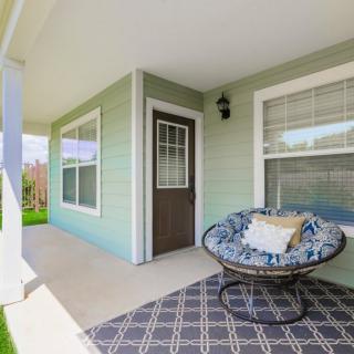 A cozy front porch with a comfortable chair and decorative rug.