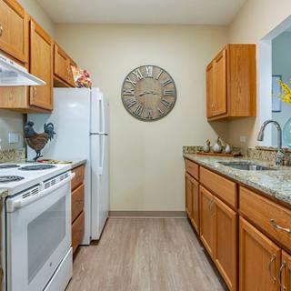 A modern kitchen with wooden cabinets and standard appliances.