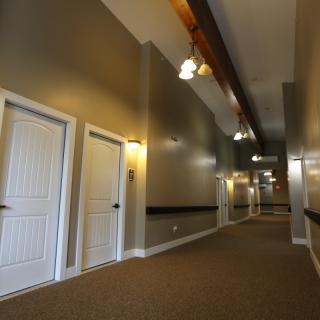A long corridor with multiple doors and overhead lighting.