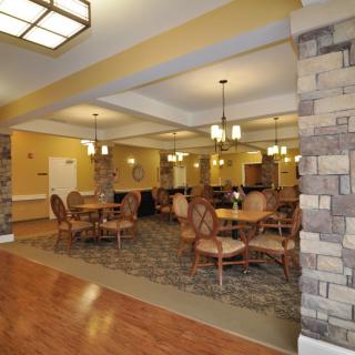 A well-lit dining area with tables and chairs, featuring stylish lighting and decor.