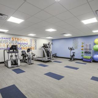 A modern gym with a variety of exercise equipment, including treadmills and stationary bikes.