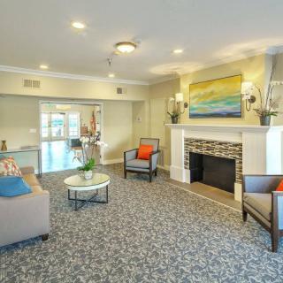 A modern living room with stylish furniture, a fireplace, and colorful artwork on the wall.