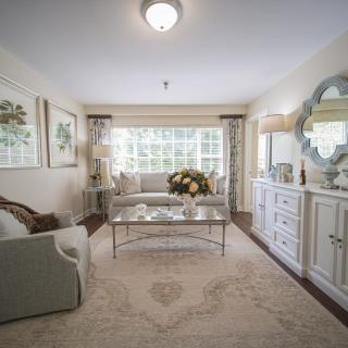 A beautifully decorated living room with elegant furniture and large windows.