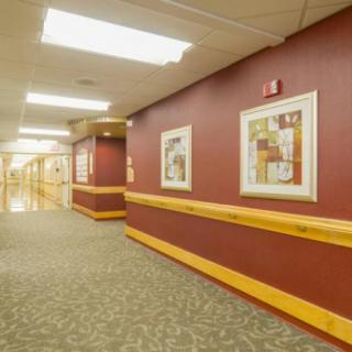 A well-lit hospital hallway featuring framed artwork on the walls.