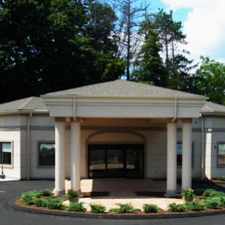 A modern building with a welcoming entrance and landscaped surroundings.