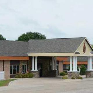 A single-story building with a prominent entrance, featuring columns and a gable roof.