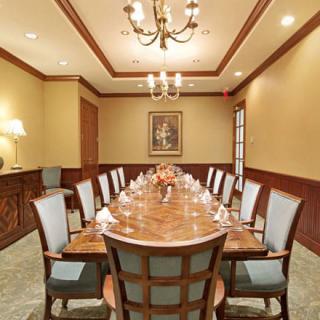 A formal conference room with a long wooden table and chairs arranged for a meeting.