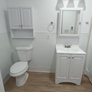 A clean and modern bathroom featuring white fixtures and minimalistic design.