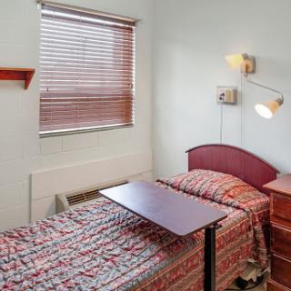 A cozy bedroom featuring two beds with patterned bedding and a small table.