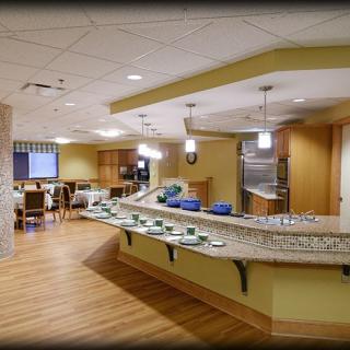 A spacious and modern kitchen area with a curved countertop and seating arrangement.