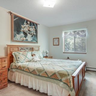 A cozy bedroom with a wooden bed frame, matching furniture, and wall decor.