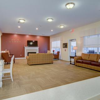 A spacious living room with sofas, a fireplace, and soft lighting.