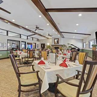 A well-appointed restaurant dining area with neatly set tables and red napkins.