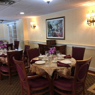 A beautifully arranged dining room with elegant table settings and floral centerpieces.