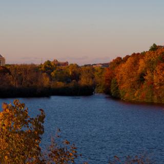 A tranquil river scene surrounded by vibrant autumn foliage.