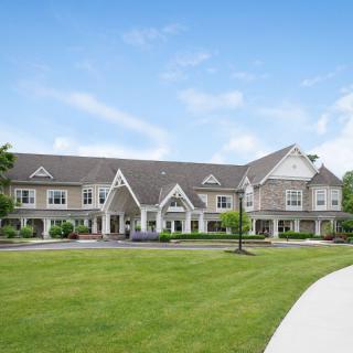 A large residential building with manicured lawns and clear blue sky.