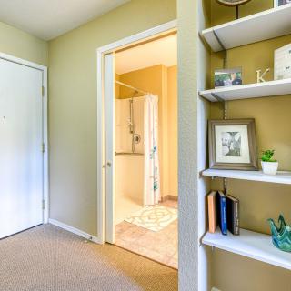 A cozy room with a bookshelf and an open door leading to another area.