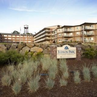 A view of a large residential building with a sign reading 'Linden Park Retirement Residence' amidst landscaped grounds.