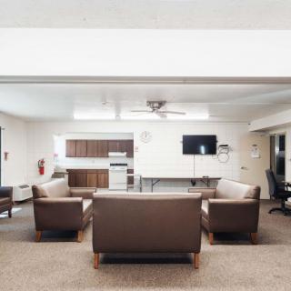 A modern and minimalist living room with sofas, a television, and a clean design.
