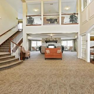 A spacious lobby with a large staircase and comfortable seating area.