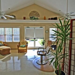 A bright and airy salon interior with comfortable seating and large windows.