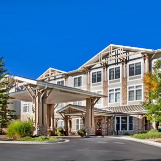 A modern residential building with a covered entrance on a sunny day.