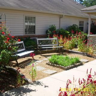 A serene garden area with benches surrounded by colorful flowers.