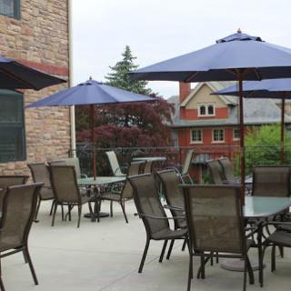 A cozy outdoor patio area with tables, chairs, and umbrellas, perfect for dining al fresco.
