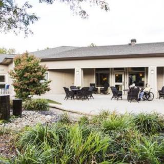 A view of a building with an outdoor patio area, surrounded by greenery.