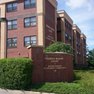 A brick building on a college campus with a sign identifying it as 'Thomas Nelson Community College'.