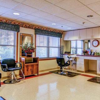 A well-lit salon interior featuring styling chairs, mirrors, and a cozy waiting area.