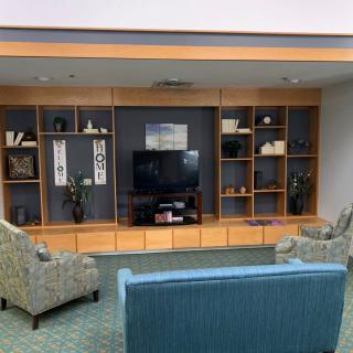 A cozy living room setup with a television and decorative shelving.