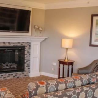 A cozy living room featuring a fireplace, wall-mounted television, and stylish furniture.