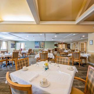 An elegantly arranged dining area with neatly set tables and chairs.