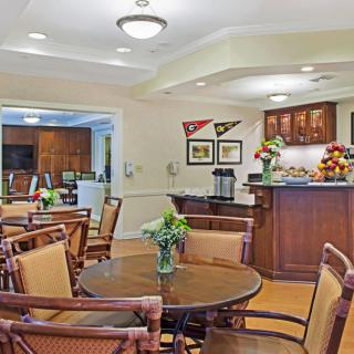 A cozy dining area with wooden furniture and a small kitchen space.