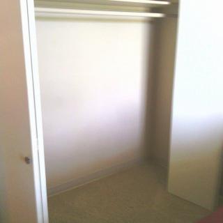 An empty closet interior with sliding doors.