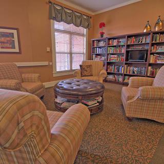 A cozy library with armchairs and bookshelves creating a warm, inviting atmosphere.