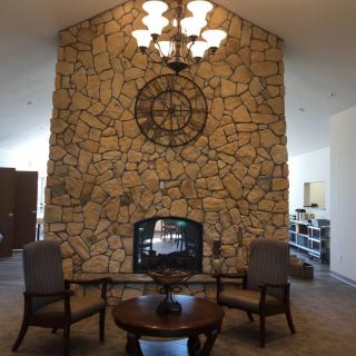 A cozy living room with a stone fireplace and elegant seating arrangement.